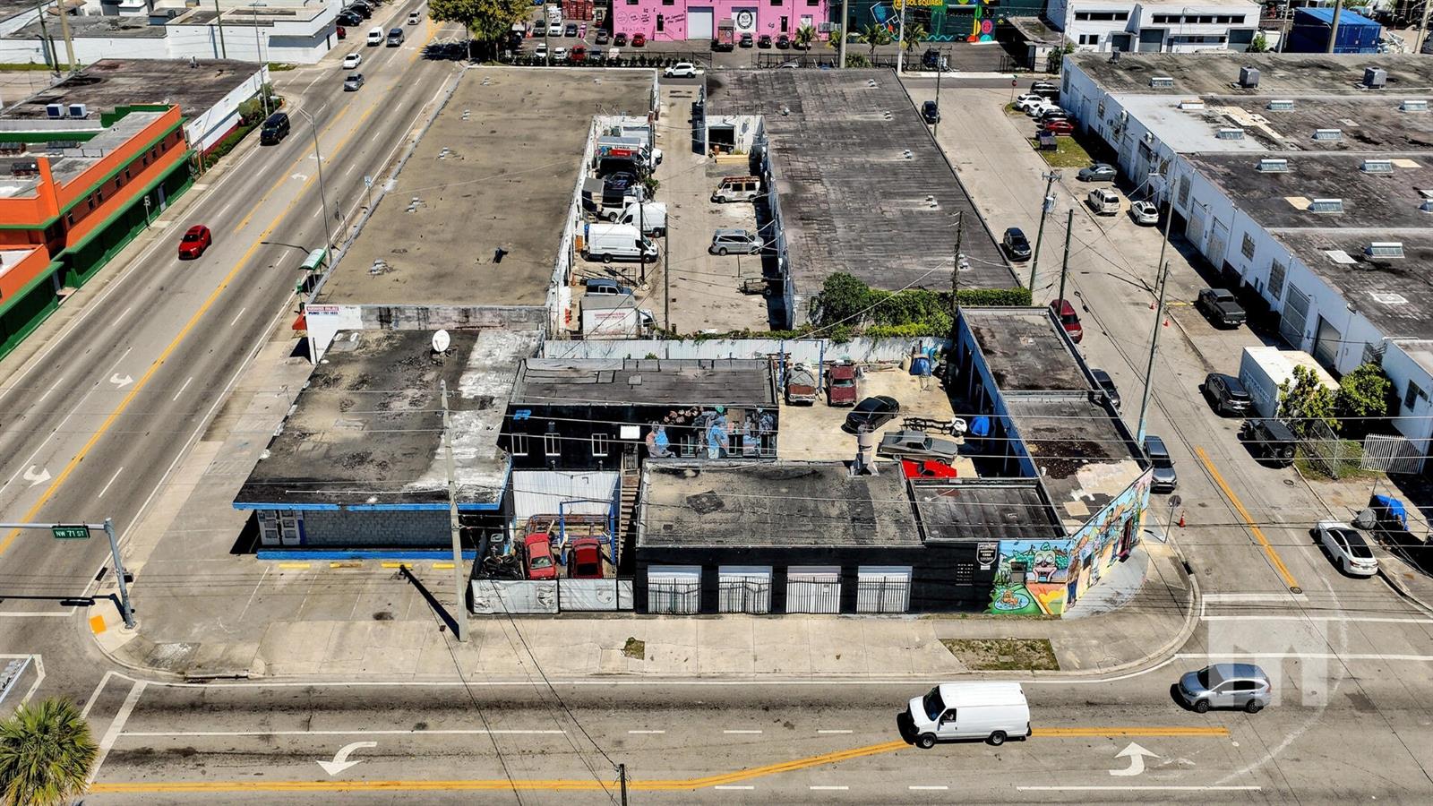 An aerial view shows a commercial building with a flat roof and adjacent parking lot — 7101 NW 7th Avenue, Miami FL 33150, MIAMI, FL