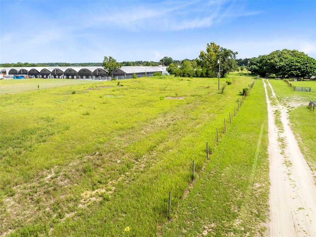 An aerial view of a grassy field with a dirt path and a wire fence — 2719 W KELLY PARK ROAD, APOPKA, FL