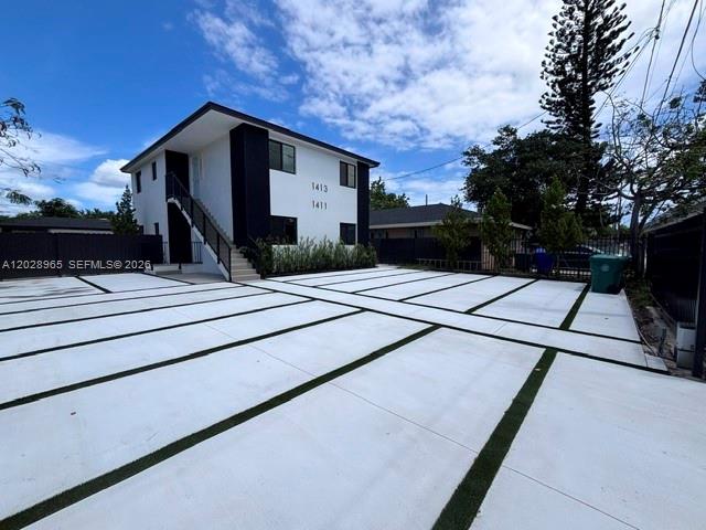 A two-story building features a modern exterior with a large, grid-patterned concrete parking area — 1411 NW 40th St # 1, Miami FL 33142, MIAMI, FL