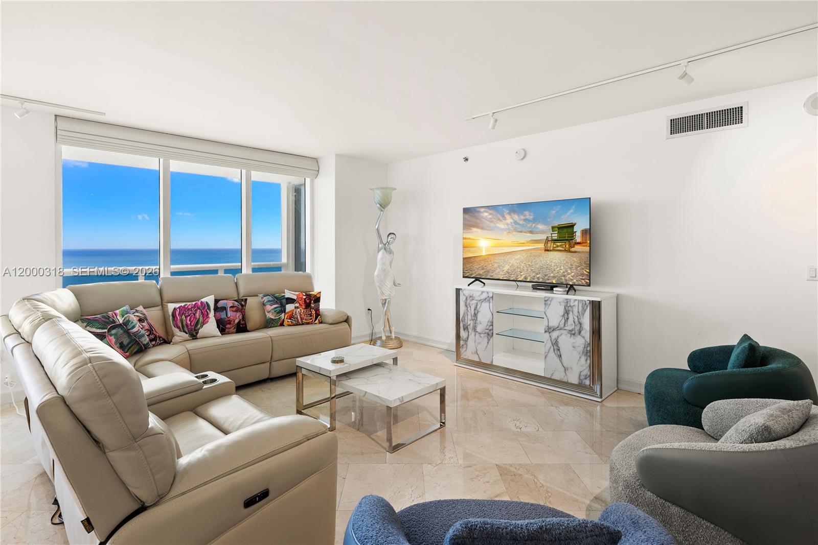 A living room features a beige sectional sofa, marble-topped tables, and an ocean view — 1850 S Ocean Dr # 3301, Hallandale Beach FL 33009, HALLANDALE BEACH, FL