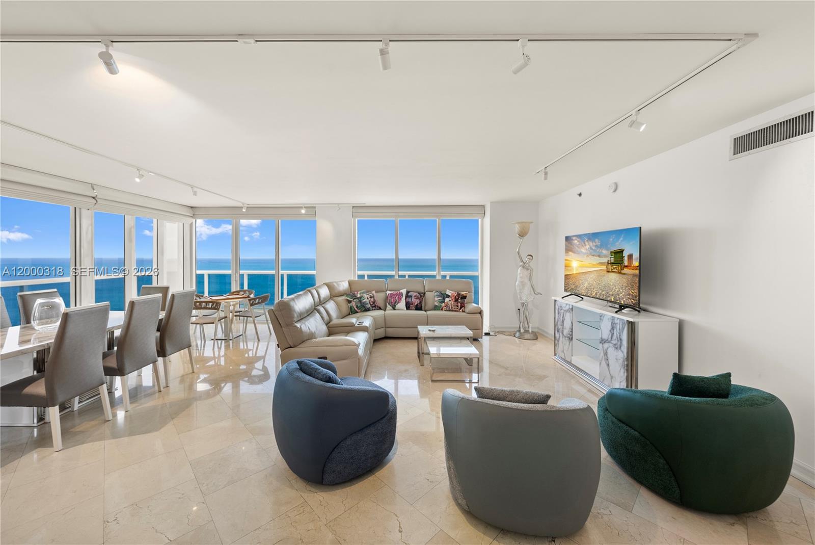 A bright living and dining area features marble floors, modern furniture, and floor-to-ceiling ocean views — 1850 S Ocean Dr # 3301, Hallandale Beach FL 33009, HALLANDALE BEACH, FL
