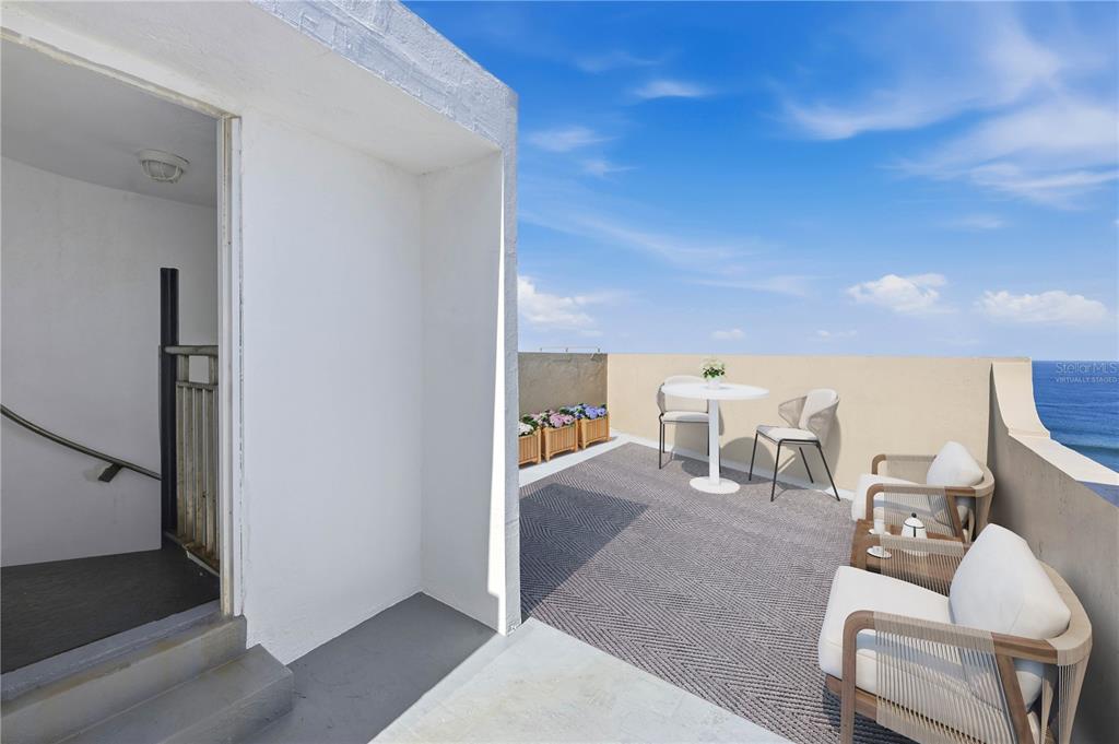A rooftop terrace features a grey rug, outdoor seating, a small table, and ocean views — 418-419 NORZAGARAY AND SOL STREETS, SAN JUAN, PR
