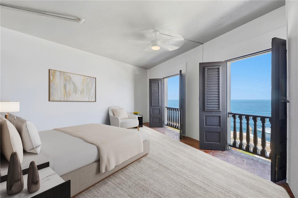 A bedroom with a bed, an armchair, and open doors leading to an oceanfront balcony — 418-419 NORZAGARAY AND SOL STREETS, SAN JUAN, PR
