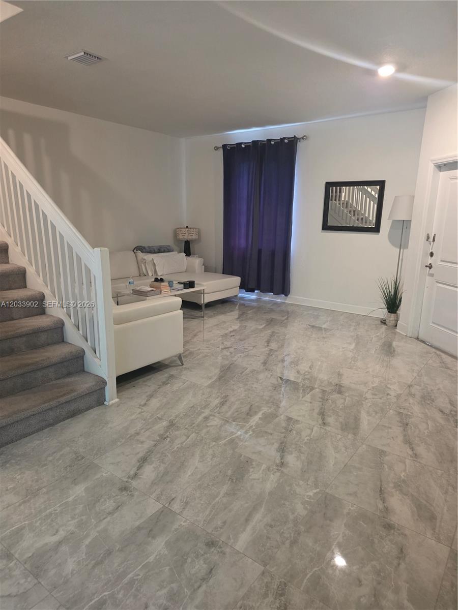 A living room features gray marble tile flooring, a white sectional sofa, and a staircase — 21124 NE 8th Ave, Miami FL 33179, MIAMI, FL