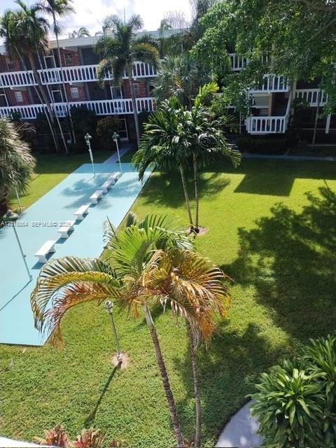 An elevated view shows a grassy courtyard with palm trees and a paved walkway — 201 NE 14th Ave # 10C, Hallandale Beach FL 33009, HALLANDALE BEACH, FL