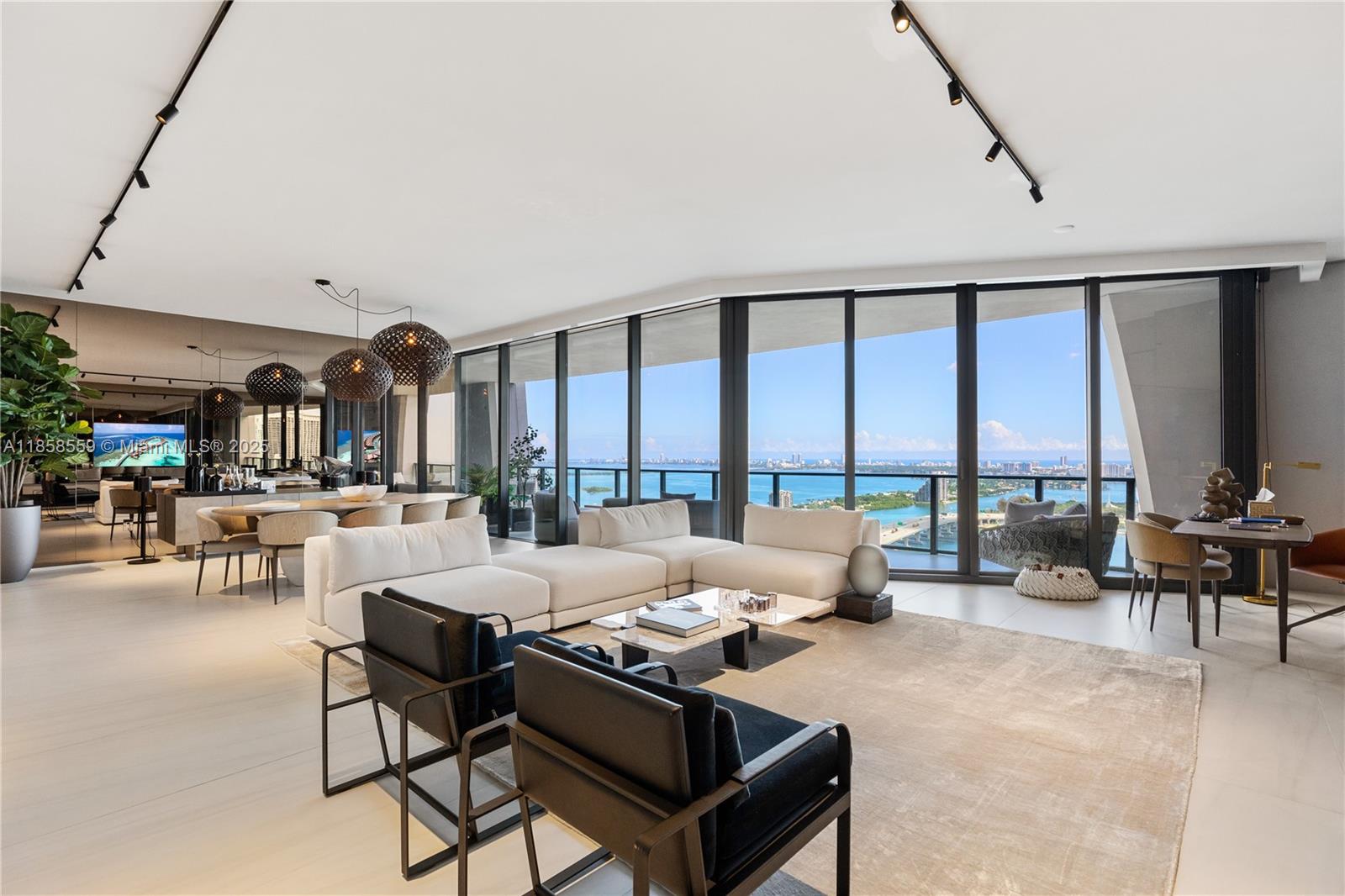 A modern living room features a white sectional, black armchairs, and floor-to-ceiling windows overlooking water — 1000 Biscayne Blvd # 3502, Miami FL 33132, MIAMI, FL