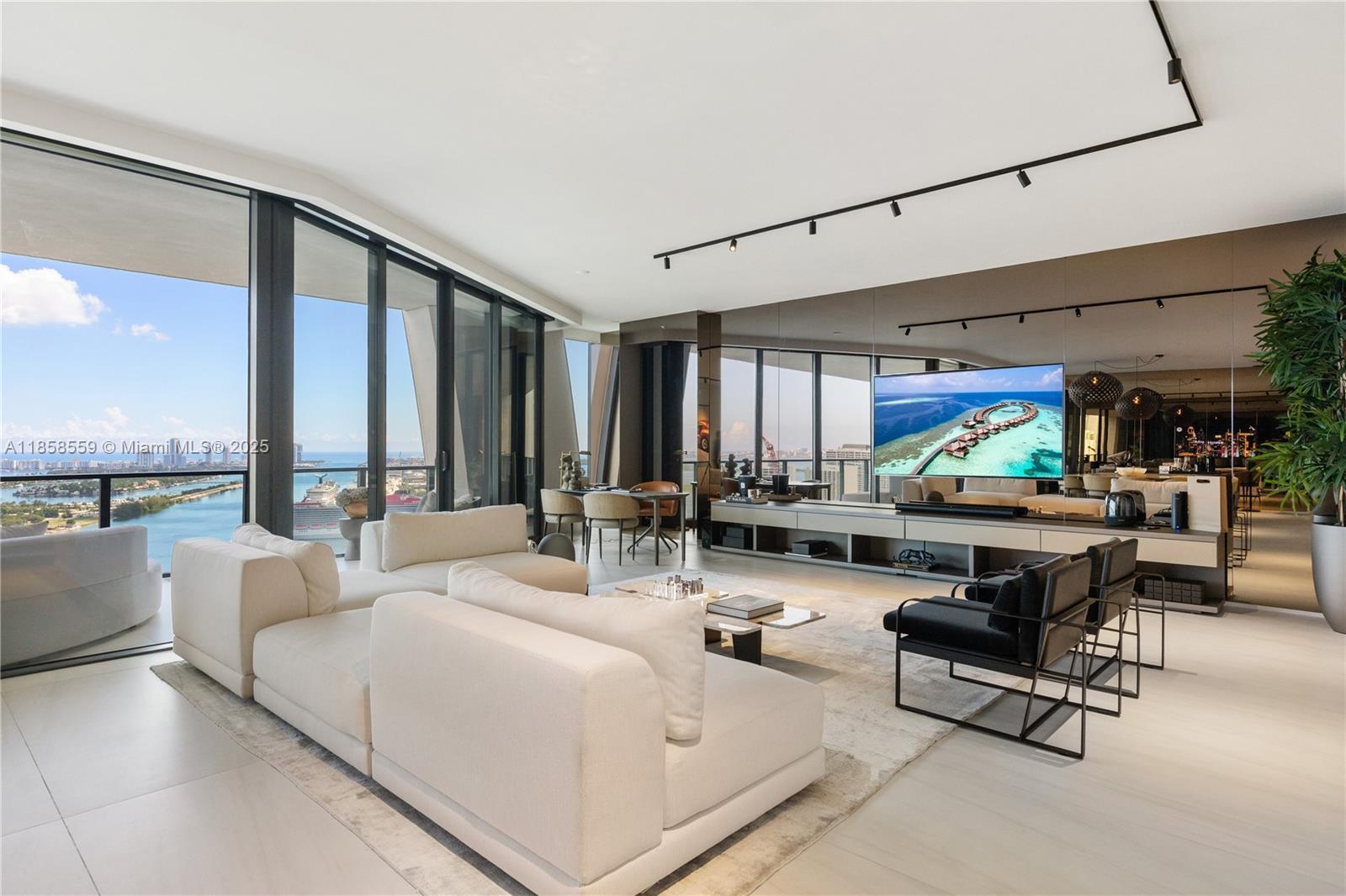 A modern living room features a large white sectional, black armchairs, and floor-to-ceiling windows — 1000 Biscayne Blvd # 3502, Miami FL 33132, MIAMI, FL