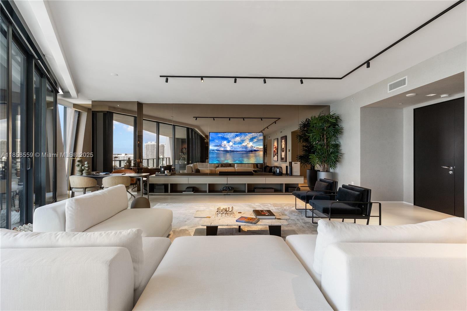 A modern living room features white sofas, a marble coffee table, and a wall-mounted television — 1000 Biscayne Blvd # 3502, Miami FL 33132, MIAMI, FL