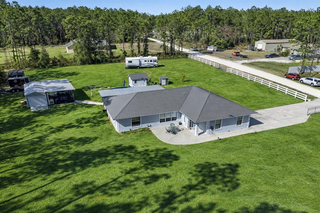 An aerial view shows a single-story house with a metal roof, patio, and detached garage — 11920 SW 45TH STREET, OCALA, FL
