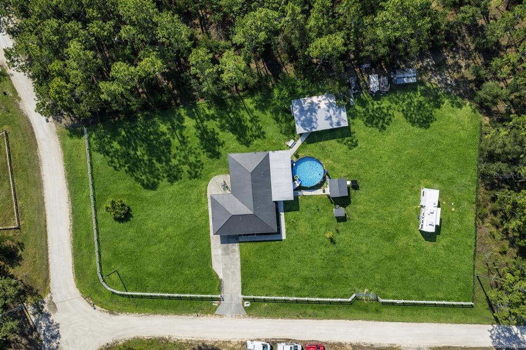 An aerial view shows a house with a pool, detached garage, and RV on a lot — 11920 SW 45TH STREET, OCALA, FL