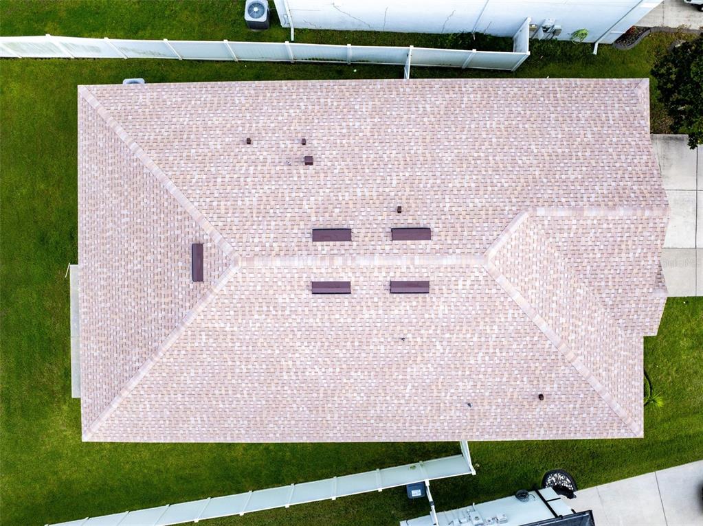An aerial view shows the shingled roof of a house with several vents and chimneys — 4379 MOON SHADOW LOOP, MULBERRY, FL