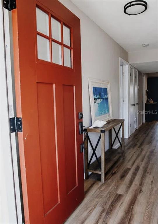 An entryway features a red front door, a wooden console table, and light wood flooring — 265 W TOWNE PLACE, TITUSVILLE, FL