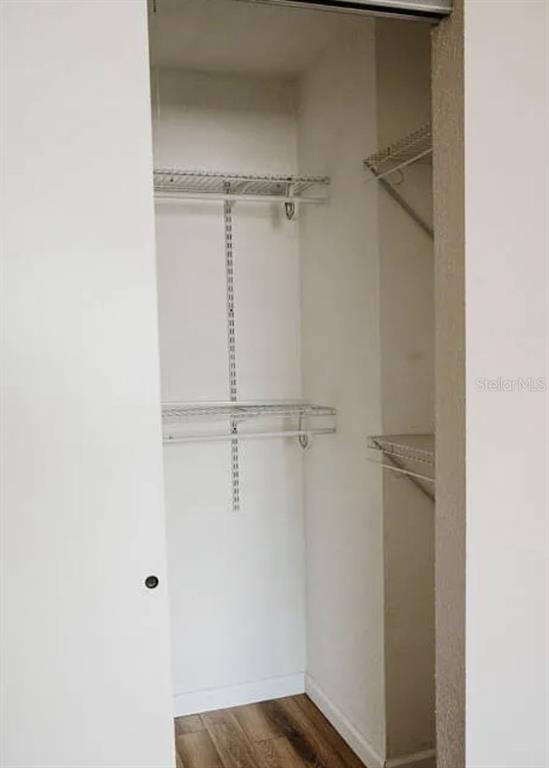 A closet with white walls, wire shelving, and wood-look flooring — 265 W TOWNE PLACE, TITUSVILLE, FL
