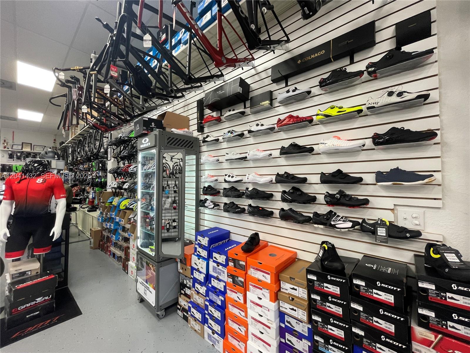 This retail bike shop features walls lined with cycling shoes, bike frames, and inventory boxes — 14097 SW 88th St, Miami FL 33186, MIAMI, FL