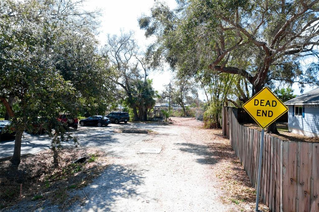 A dirt road leads to a parking area next to a wooden fence and trees — 4101 S SCHOOL AVENUE, SARASOTA, FL