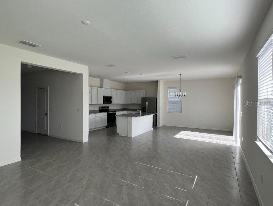 An open-concept kitchen with white cabinets, a central island, and tile flooring — 9112 WESTSIDE HILLS DRIVE, DAVENPORT, FL