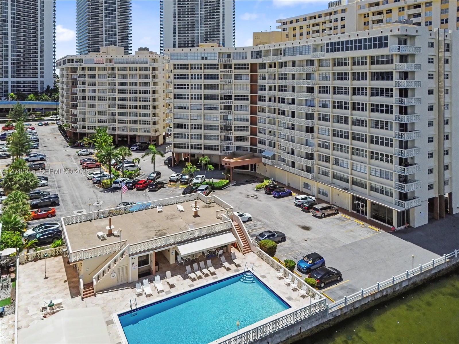 An aerial view shows a large apartment complex with a swimming pool and parking lot — 1817 S Ocean Dr # 620, Hallandale Beach FL 33009, HALLANDALE BEACH, FL