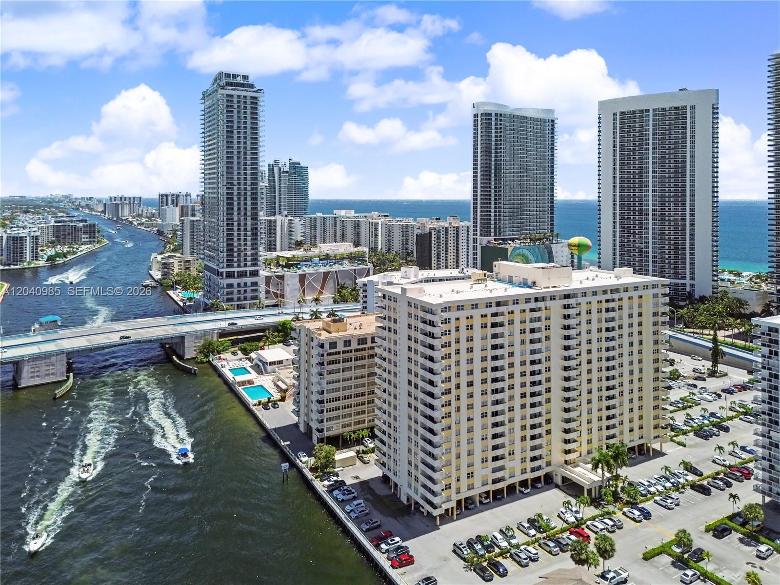An aerial view shows high-rise apartment buildings, a bridge, and a waterway with boats — 1817 S Ocean Dr # 620, Hallandale Beach FL 33009, HALLANDALE BEACH, FL