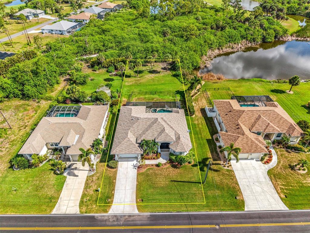 An aerial view shows a single-family house with a pool and a large backyard — 1146 ROTONDA CIRCLE, ROTONDA WEST, FL