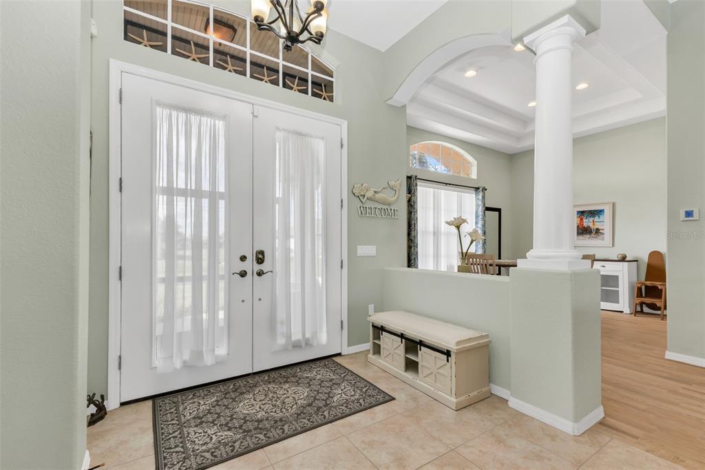 An entryway features double doors, a bench, a column, and light green walls — 1146 ROTONDA CIRCLE, ROTONDA WEST, FL