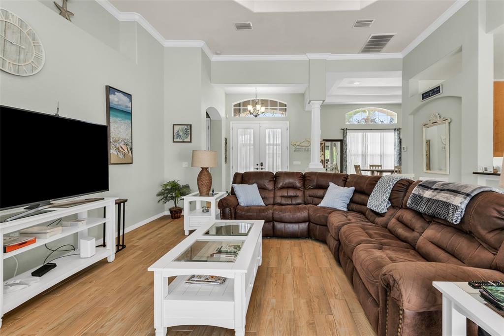 A living room features a large brown sectional sofa, a white coffee table, and a television — 1146 ROTONDA CIRCLE, ROTONDA WEST, FL