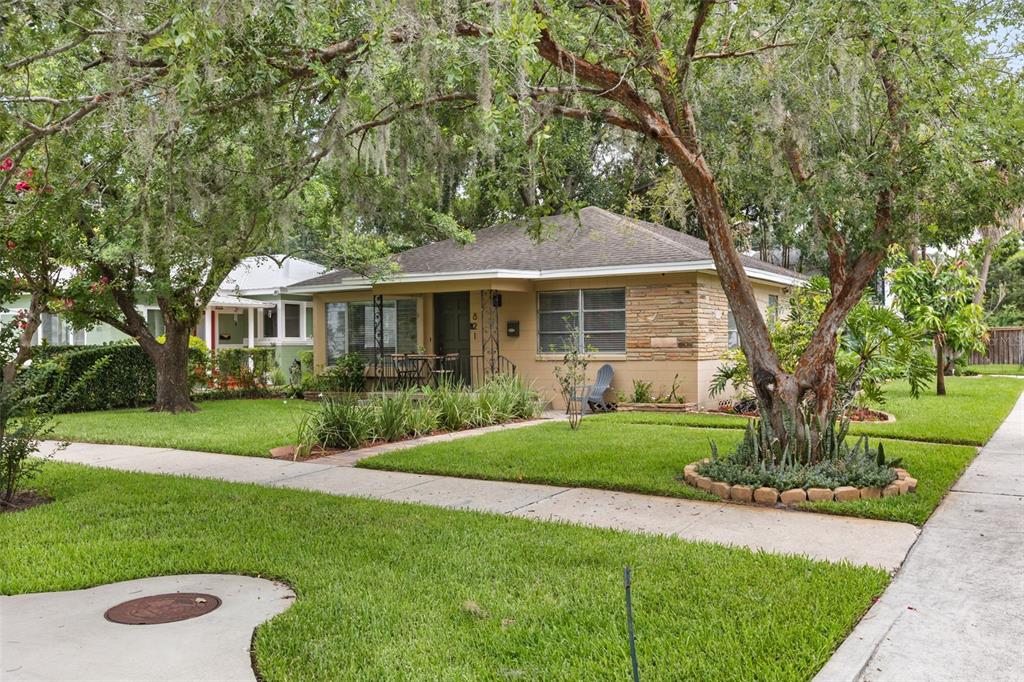 A single-story house with a stone facade and a front lawn under large trees — 821 E CHURCH STREET, ORLANDO, FL