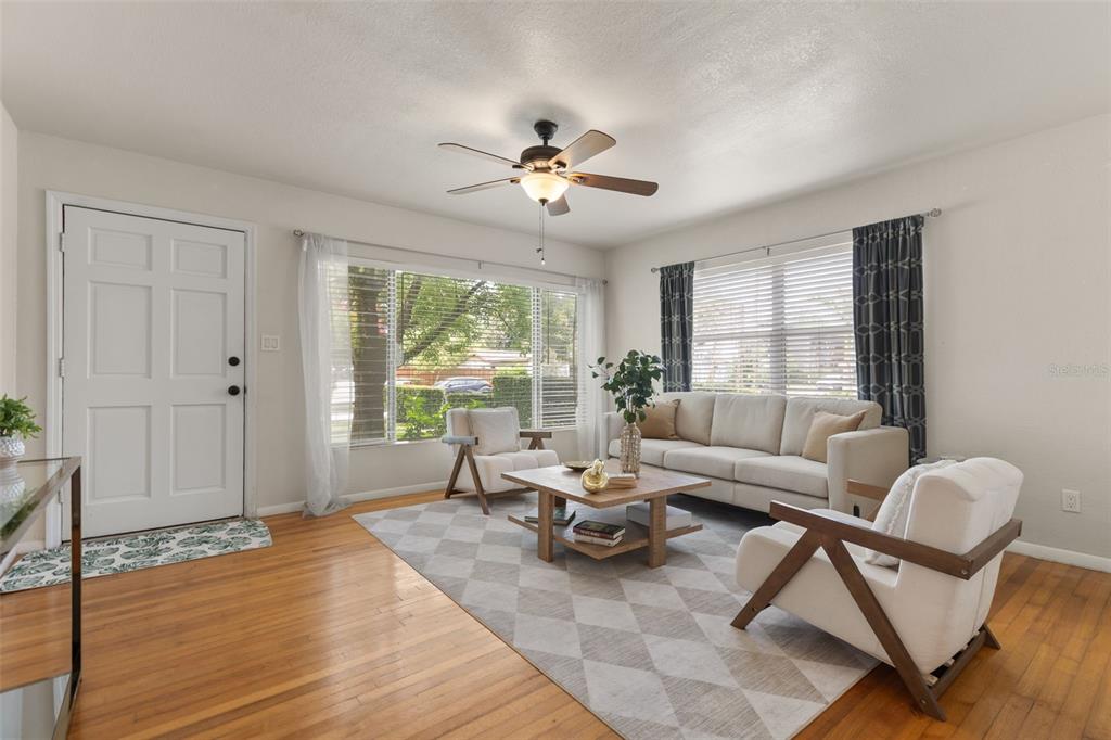 A living room features hardwood floors, a ceiling fan, a sofa, and two armchairs — 821 E CHURCH STREET, ORLANDO, FL