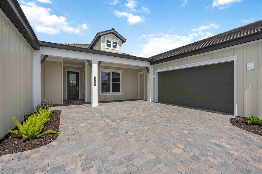 A paved driveway leads to the front entrance and a two-car garage of a house — 18185 HOME RUN DRIVE, VENICE, FL