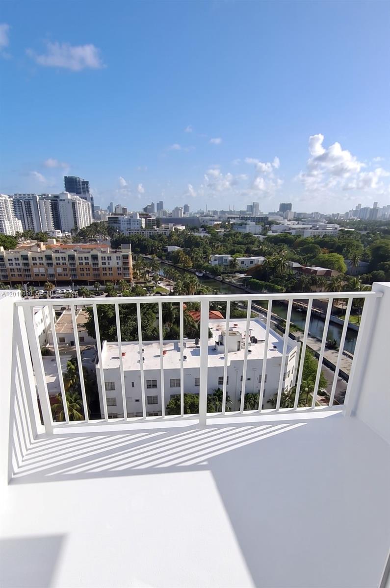 A high-angle view from a white balcony overlooking a city skyline, canal, and buildings — 2829 Indian Creek Dr # 1405, Miami Beach FL 33140, MIAMI BEACH, FL