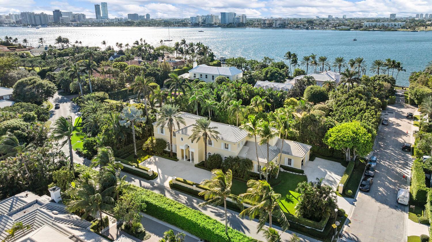 An aerial view of a yellow two-story house surrounded by lush landscaping near the water — 510 N Lake Way, Palm Beach FL 33480, PALM BEACH, FL