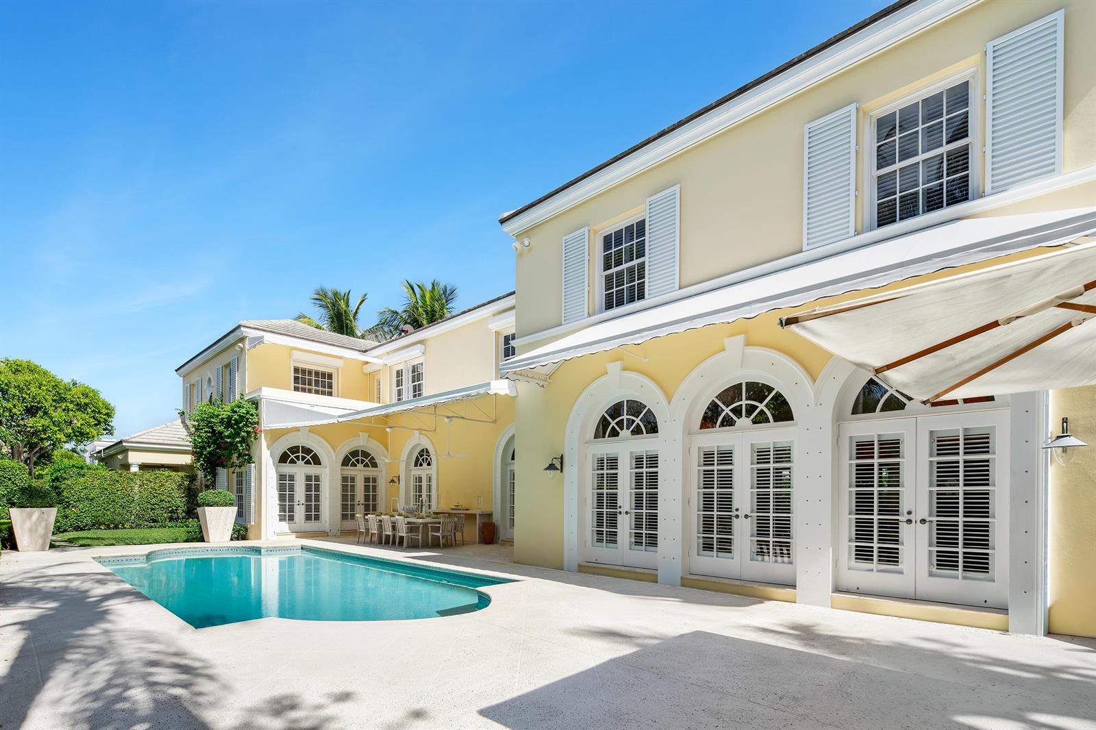 A yellow two-story house with a swimming pool and white arched doors on a patio — 510 N Lake Way, Palm Beach FL 33480, PALM BEACH, FL