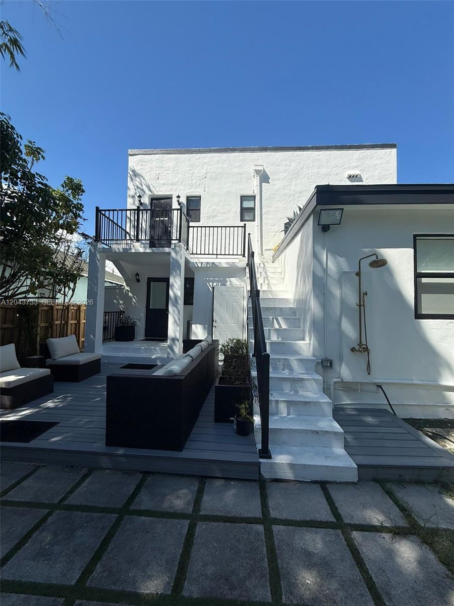 The exterior of a white building features a wooden deck, outdoor stairs, and a shower — 528 NE 70th St, Miami FL 33138, MIAMI, FL