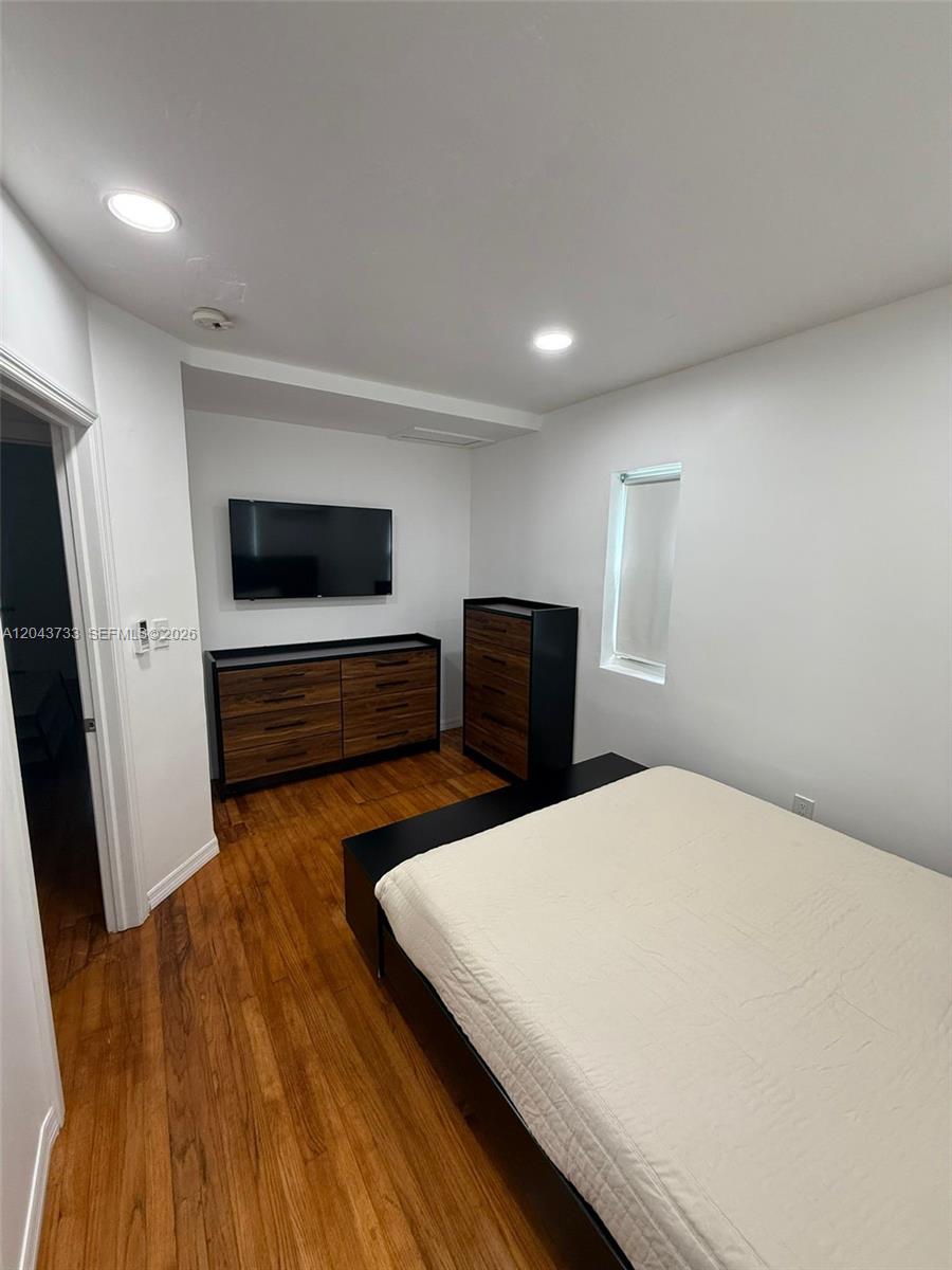 A bedroom features a bed, a dresser, a tall chest of drawers, and a television — 528 NE 70th St, Miami FL 33138, MIAMI, FL