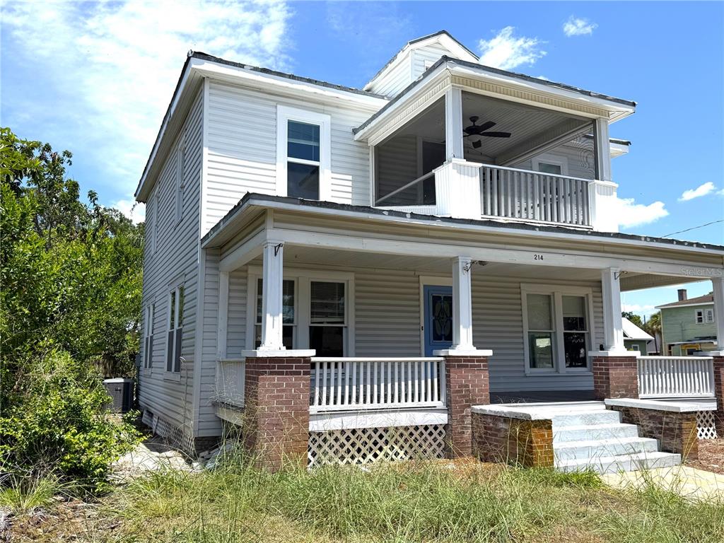 A two-story house with white siding, a front porch, and an upper-level screened balcony — 214 W WHIDDEN STREET, ARCADIA, FL