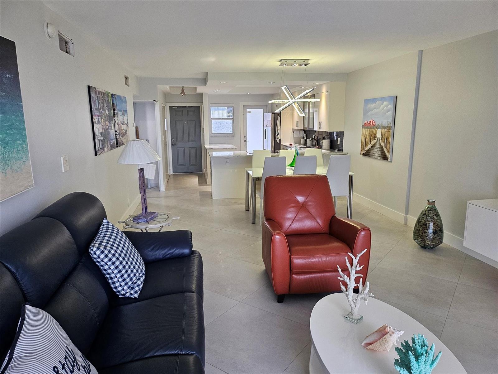 A living room and dining area feature tile floors, a leather sofa, and a recliner — 750 N Ocean Boulevard # 503, Pompano Beach FL 33062, POMPANO BEACH, FL