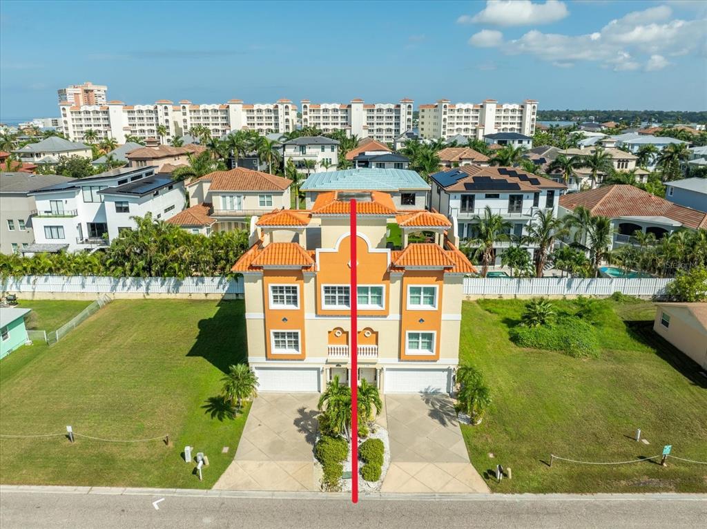 An aerial view shows a two-unit duplex with orange tile roofs and a red line — 136 175TH AVENUE E, REDINGTON SHORES, FL