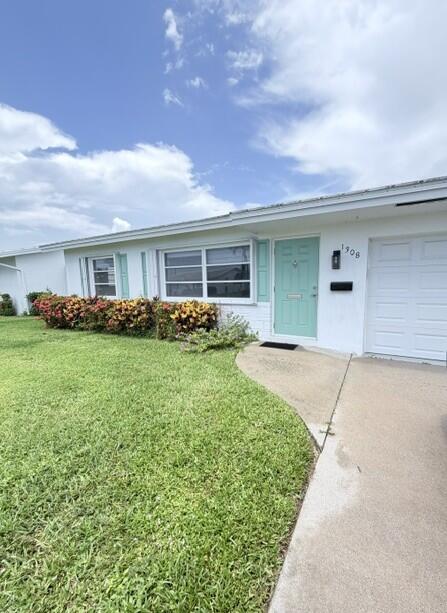 A single-story house with a light-colored exterior, a teal front door, and a green lawn — 1308 SW 24th Street, Boynton Beach FL 33426, BOYNTON BEACH, FL