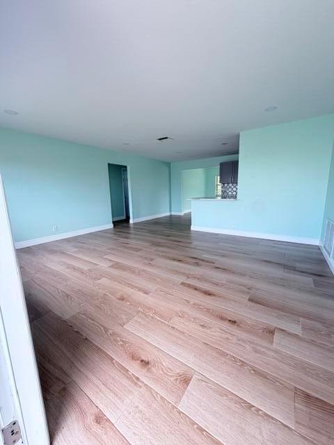 An open-concept living area features light blue walls and light wood-look flooring — 1308 SW 24th Street, Boynton Beach FL 33426, BOYNTON BEACH, FL