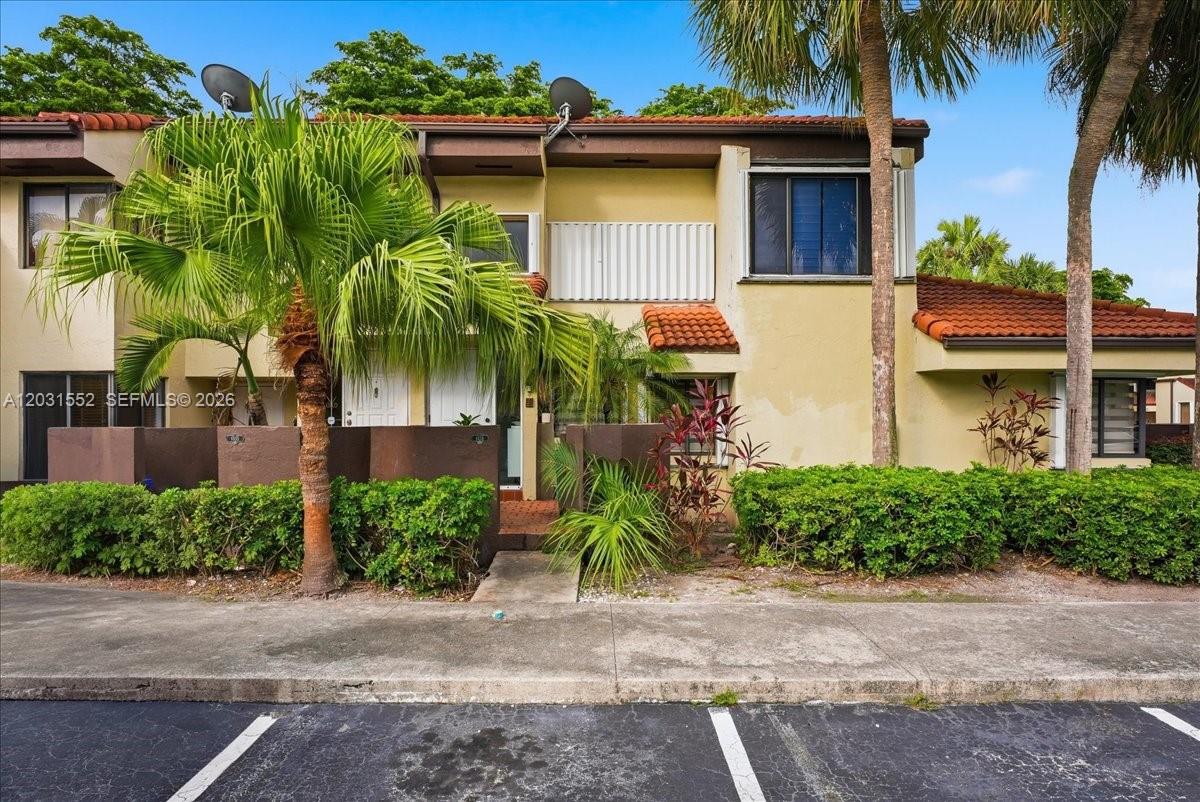 A two-story townhouse exterior features a palm tree, a small front patio, and parking spaces — 9839 SW 138th Ave, Miami FL 33186, MIAMI, FL