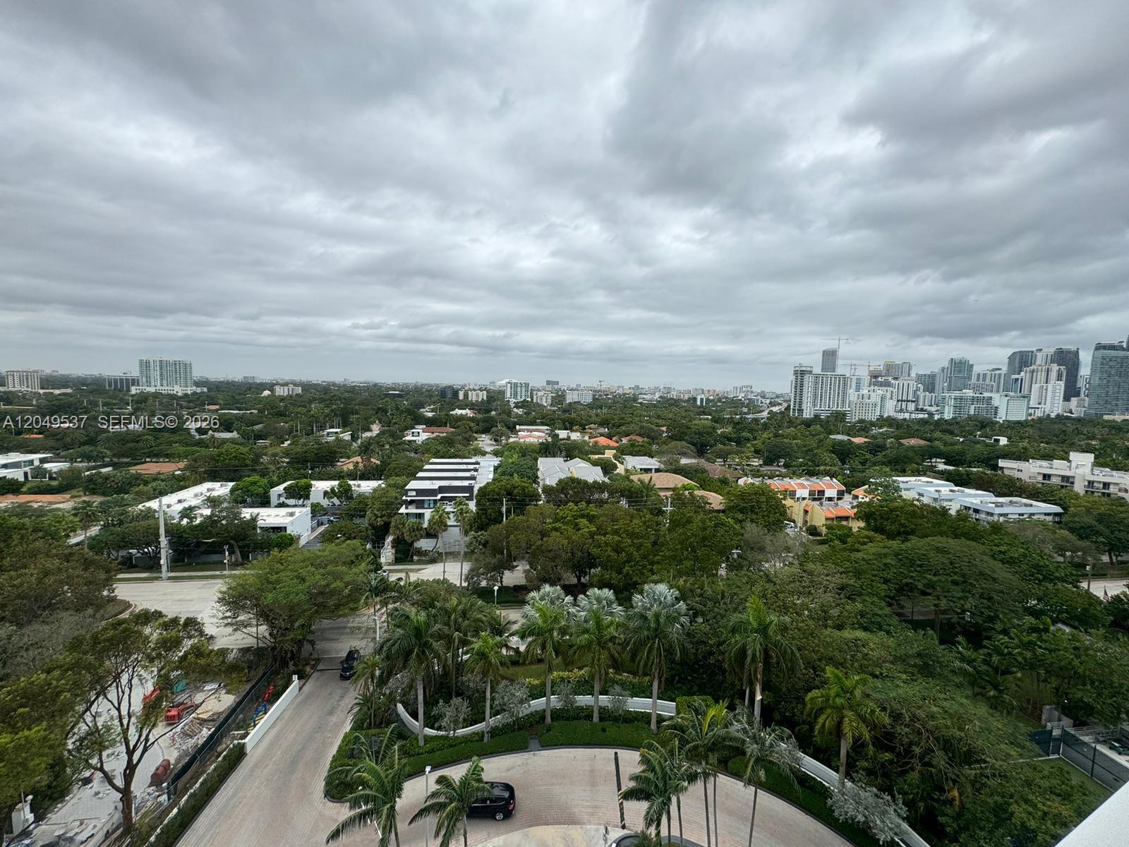 An elevated view of a suburban landscape with lush trees, buildings, and a cloudy sky — 2101 Brickell Ave # 1112, Miami FL 33129, MIAMI, FL