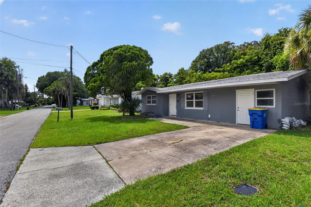 A gray single-story house with a concrete driveway and a blue trash bin outside — 305 JOYCE STREET, EDGEWATER, FL