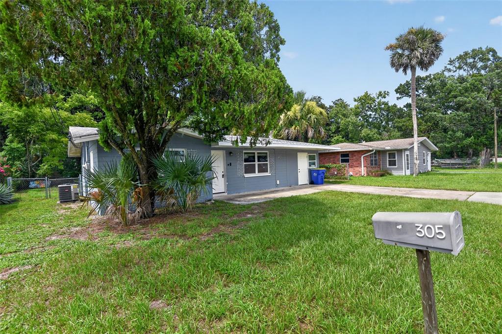 A gray single-story house with a large tree and a mailbox in the front yard — 305 JOYCE STREET, EDGEWATER, FL