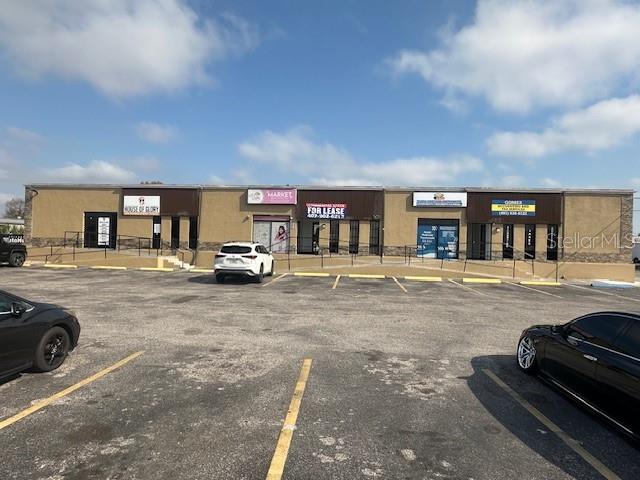 A single-story commercial strip mall with a parking lot in front — 1011 W LANCASTER ROAD, ORLANDO, FL