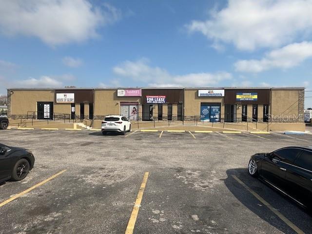A single-story commercial strip mall with multiple storefronts and a paved parking lot — 1011 W LANCASTER ROAD, ORLANDO, FL