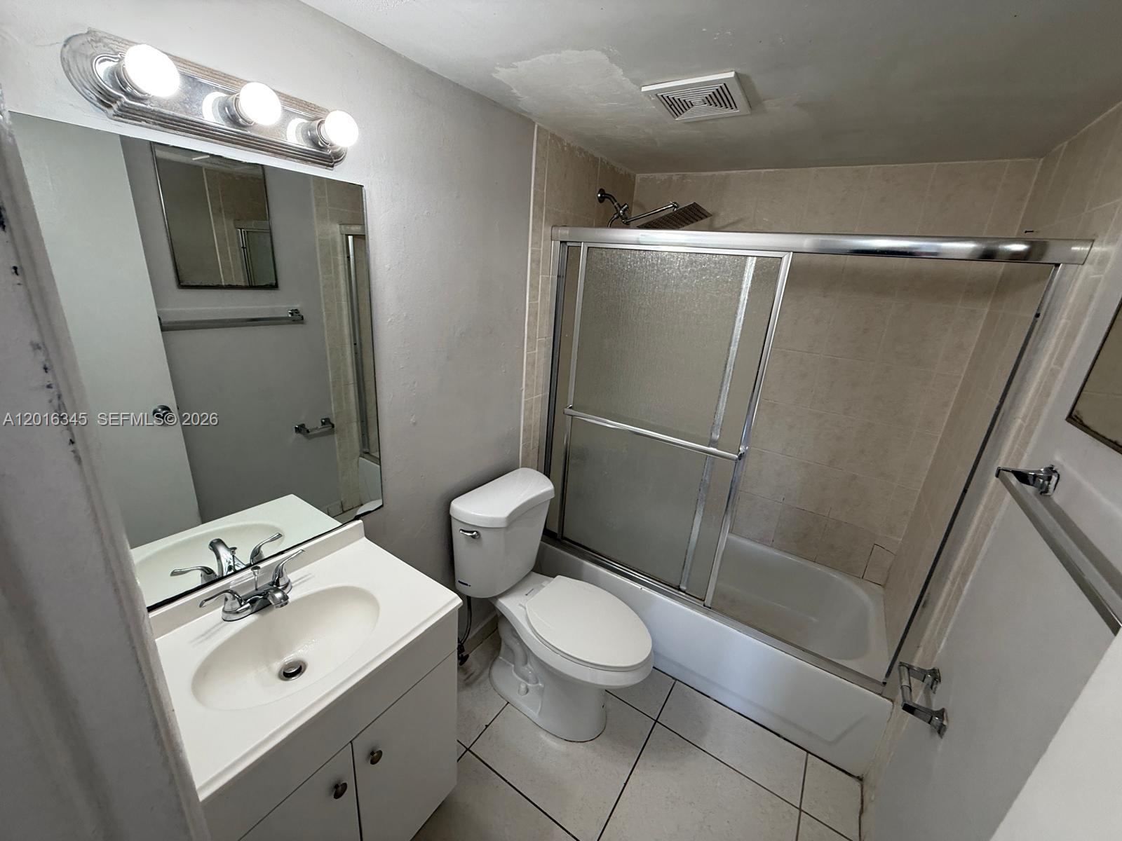A bathroom features a white vanity, a toilet, and a shower-tub combination with sliding doors — 17530 NW 68th Ave # C3004, Hialeah FL 33015, HIALEAH, FL