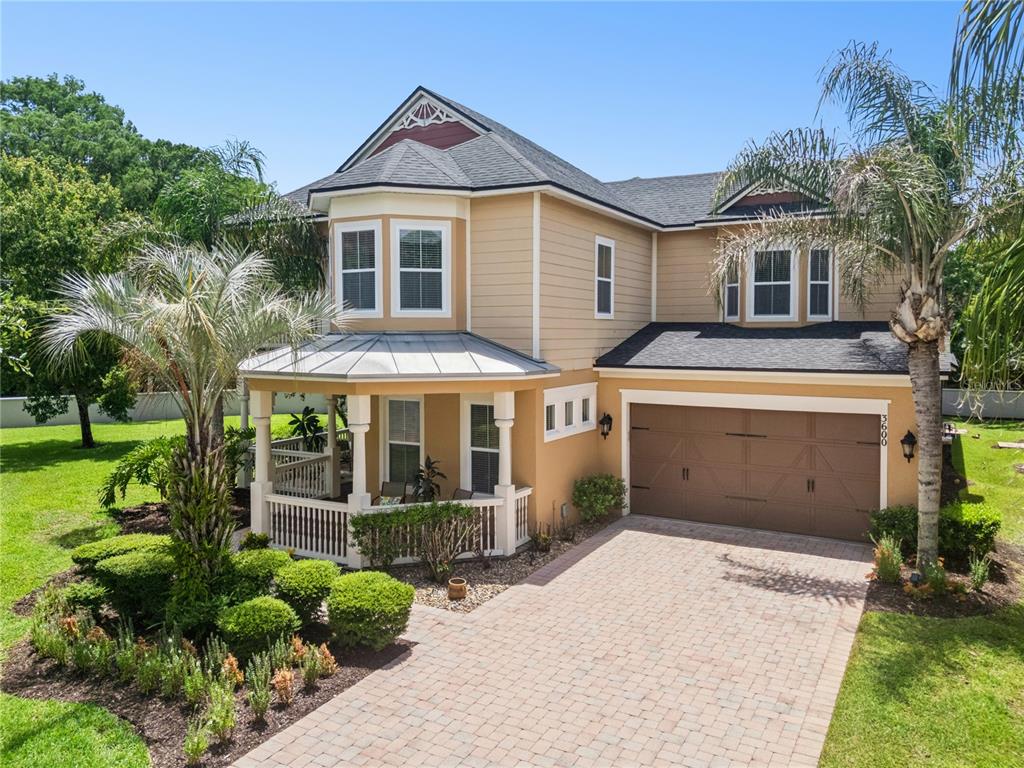 A two-story house with tan siding, a front porch, and a paved driveway — 3600 SIMONTON PLACE, LAKE MARY, FL