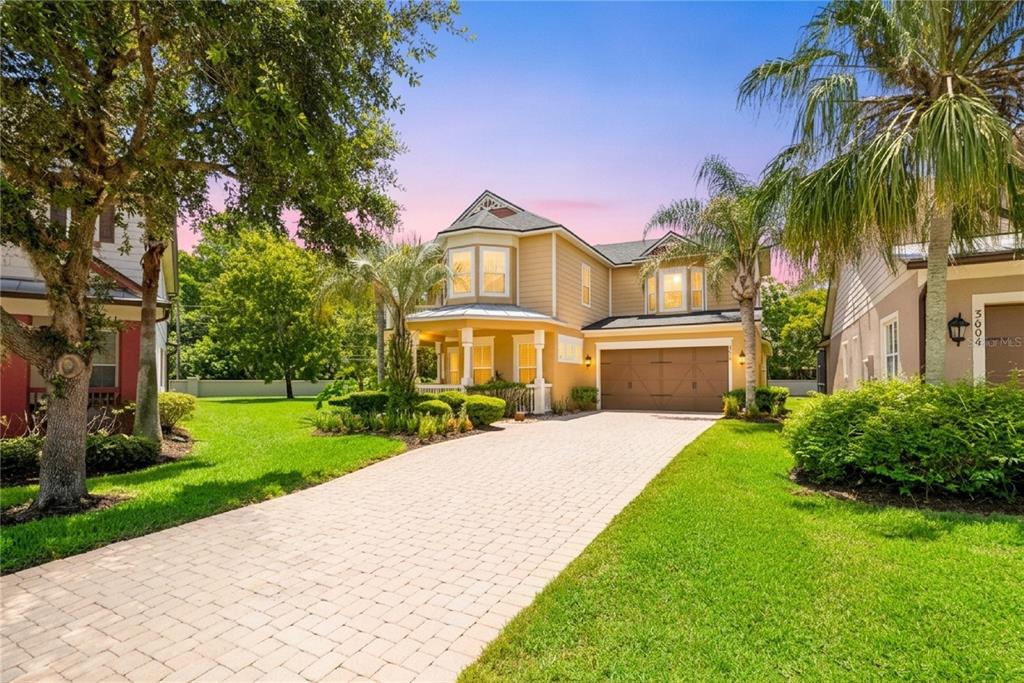 A two-story yellow house with a paved driveway, a two-car garage, and a front porch — 3600 SIMONTON PLACE, LAKE MARY, FL