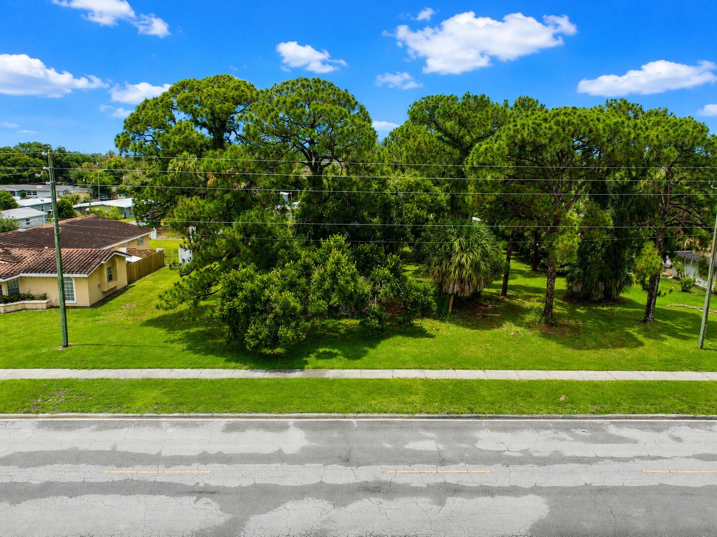 An aerial view shows a grassy lot with several large trees next to a house — 1006 Grandview Boulevard, Fort Pierce FL 34982, FORT PIERCE, FL