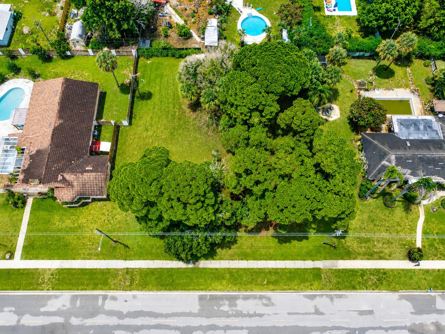 An aerial view shows a vacant, tree-filled lot situated between two houses with swimming pools — 1006 Grandview Boulevard, Fort Pierce FL 34982, FORT PIERCE, FL