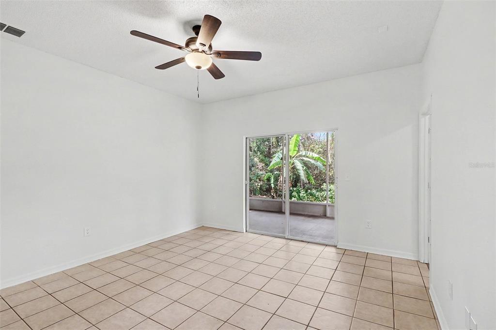 A white kitchen features stainless steel appliances, white cabinetry, and light tile flooring — 3709 CINNAMON FERN LOOP, CLERMONT, FL
